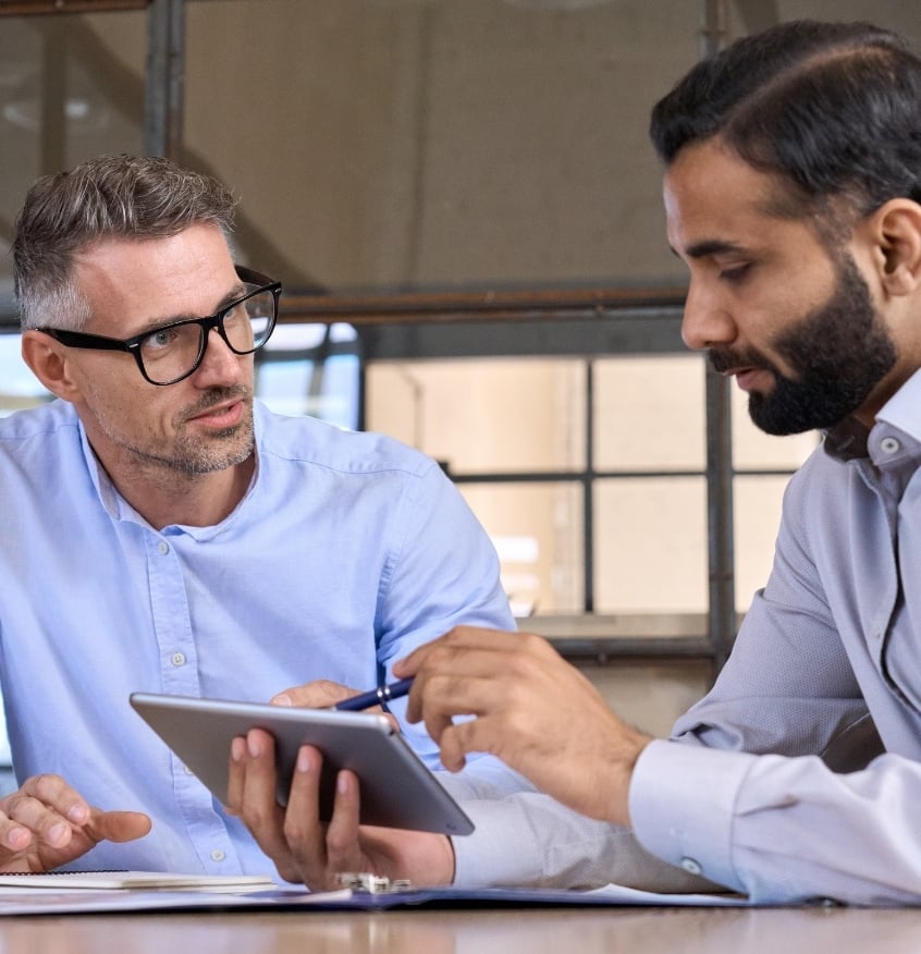 Two employees using tablet and talking