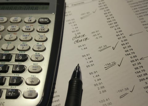 una calcolatrice e un bilancio che mostra le note di riconciliazione dei conti