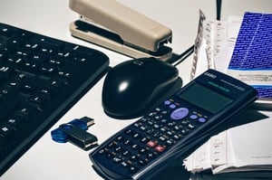 a calculator and balance sheets beside a keyboard, some of the tools of an accounting firm