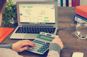 an accountant using a calculator and computer as part of their duties